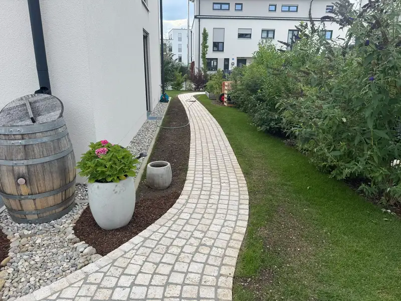 Kleinpflasterweg zwischen Rasen und Kiesband
