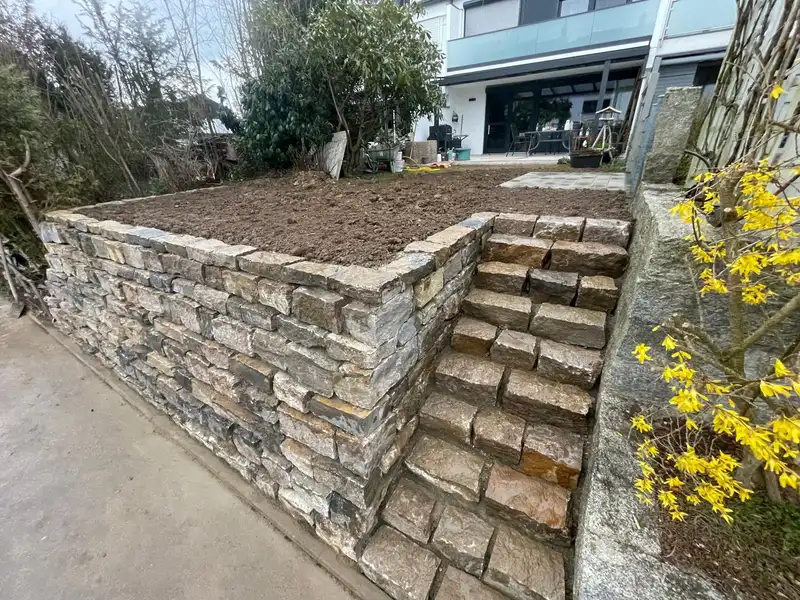 Gemauerte Natursteinmauer mit integrierter Treppe