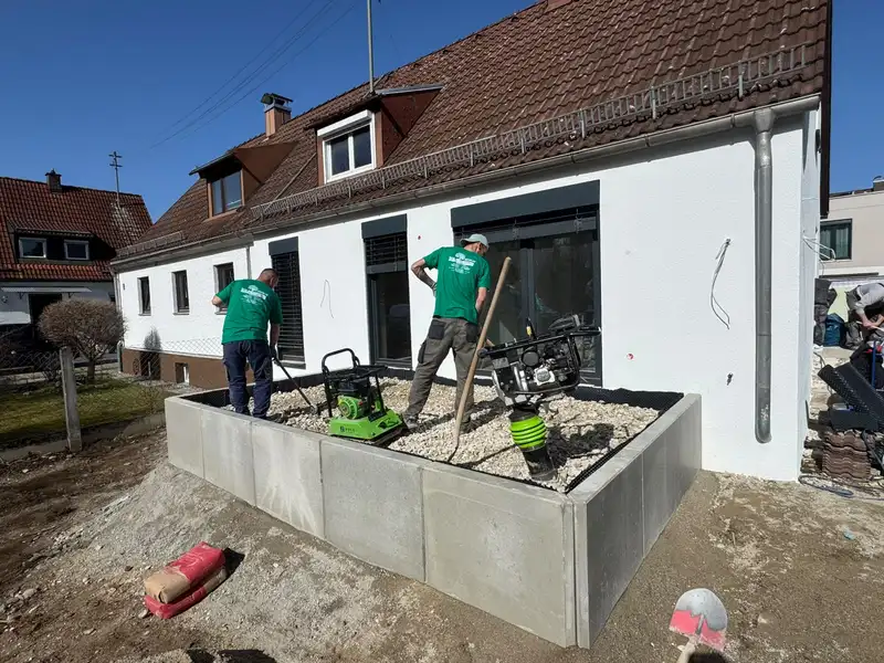 Winkelstützmauer aus L-Steinen, die Hinterfüllung wird verdichtet
