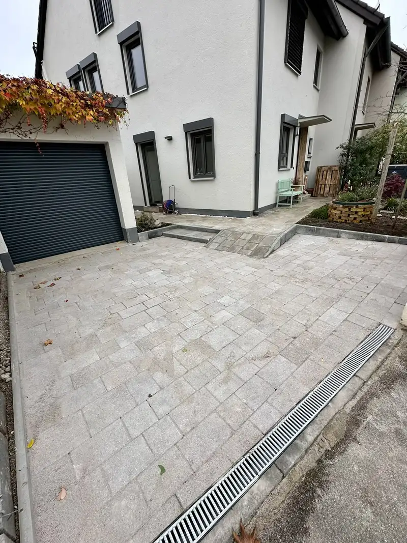 Neu gepflasterte Einfahrt mit Entwässerungsrinne vor der Garage