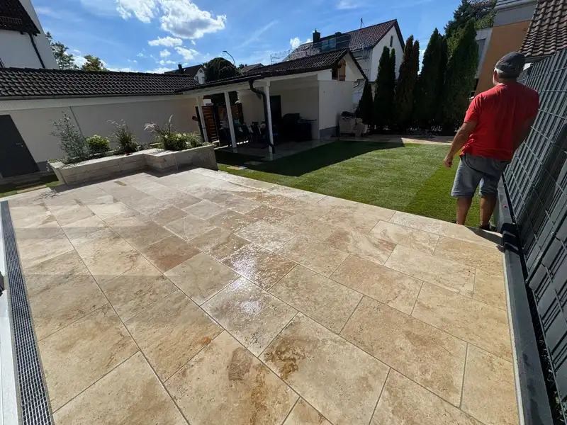 Travertin-Terrasse mit Rasenfläche hinter dem Haus
