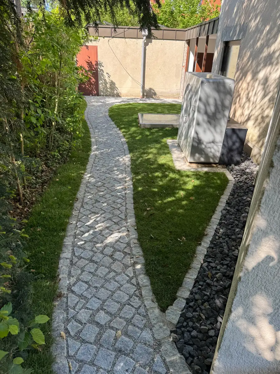 Derselbe Bereich mit Pflasterweg, Rasen und Kiesband