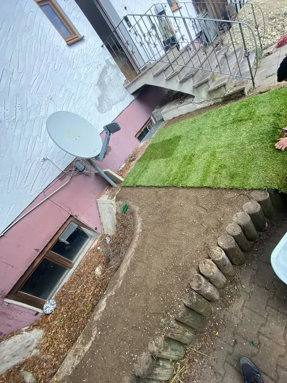 Frisch verlegter Rollrasen im Garten neben einer Treppe