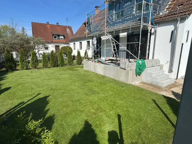 Einfamilienhaus mit neu verlegtem Rasen und Gerüst am Anbau