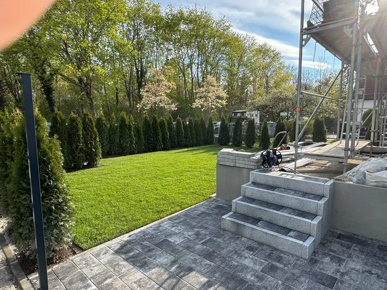 Garten mit gepflasterter Terrasse, Treppe und Gerüst