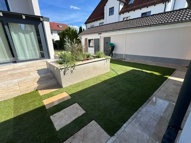 Innenhof mit neu verlegtem Rasen, Hochbeet und Terrasse