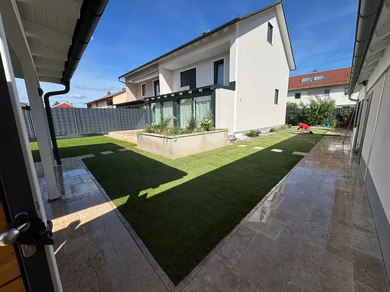 Einfamilienhaus mit frisch verlegtem Kunstrasen im Garten