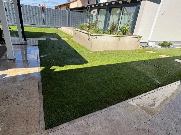 Frisch verlegter Rasen mit Bewässerung im Garten