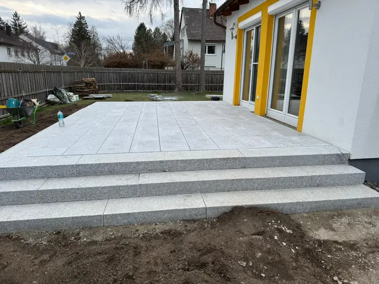 Neu geflieste Terrasse mit Granitplatten und Stufen am Wohnhaus