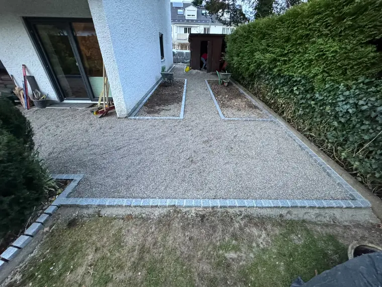 Gepflasterter Gartenweg und Kiesfläche an einem Wohnhaus