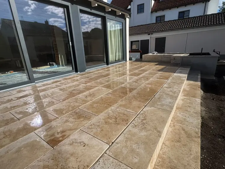 Geflieste Terrasse mit großen Glasfronten am Wohnhaus