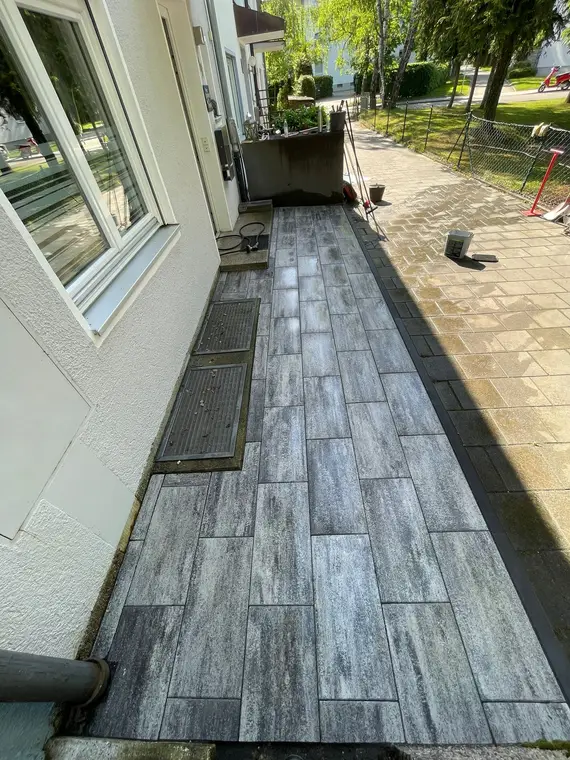 Frisch verlegter Plattenweg entlang einer Hausfassade