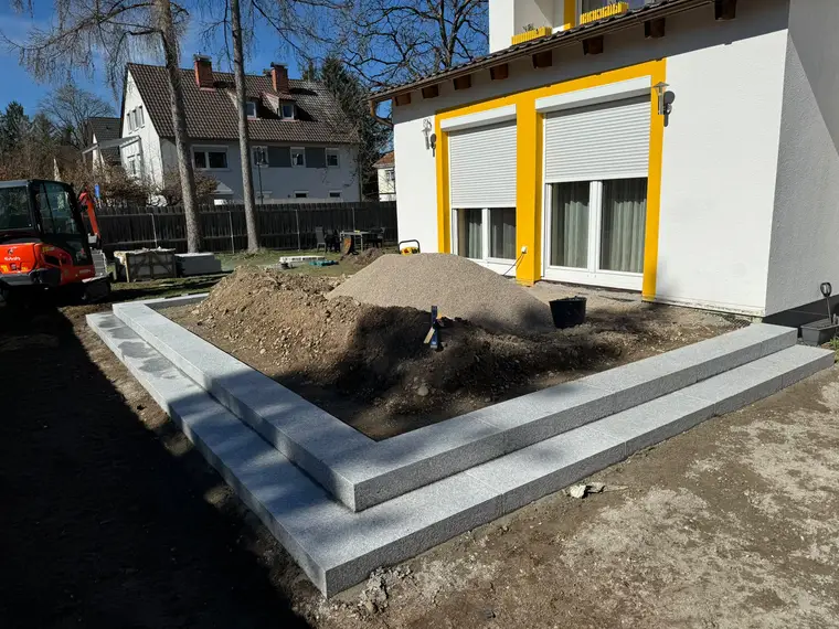 Gartenbaustelle mit Granit-Stufen, Aushub und Minibagger vor Wohnhaus