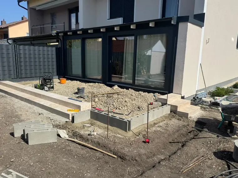Baustelle einer Terrasse mit Stufen, Schotter und Werkzeug