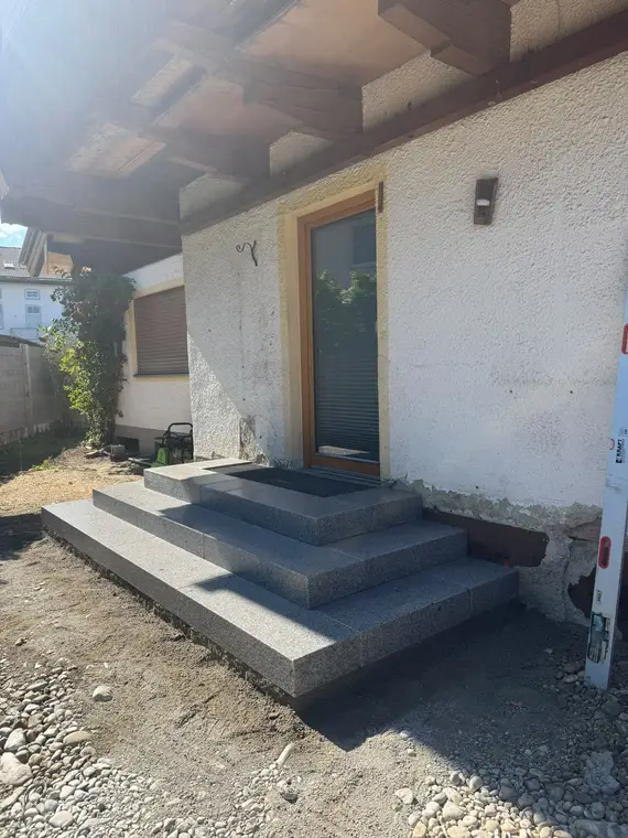 Neue Granittreppe vor einer Hauseingangstür auf einer Baustelle