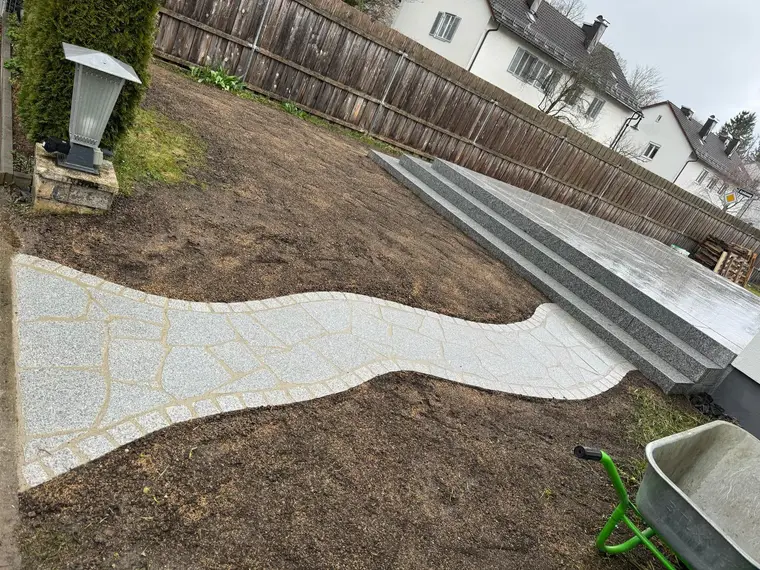 Gepflasterter Gartenweg führt zu einer geschwungenen Treppe