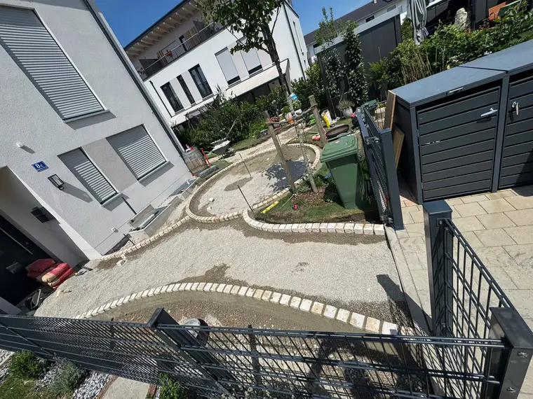 Baustelle im Garten mit gepflasterten Wegen und Kiesbetten