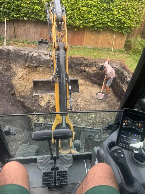Blick aus dem Bagger auf Erdaushubarbeiten im Garten