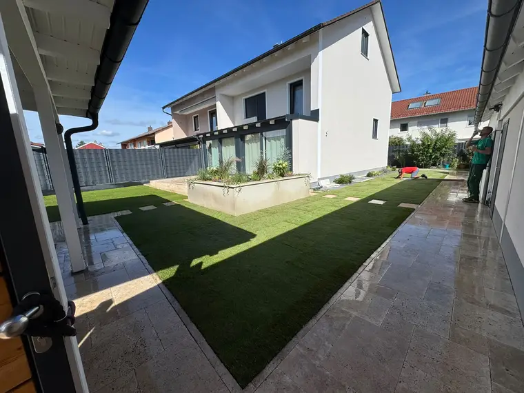 Modernes Wohnhaus mit frisch verlegtem Rasen und Gartenarbeiten